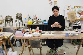 Onka Allmayer-Beck Ton modellierend am Tisch in ihrer Werkstatt