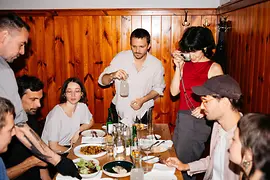 Personas sentadas a una mesa con comida en una taberna vienesa.