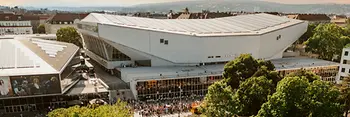 Veduta aerea della Wiener Stadthalle al tramonto, persone in attesa di entrare.