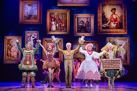 Les personnages de la comédie musicale : le réveil, la danseuse, le candélabre, la tour Eiffel et l'armoire sur scène.