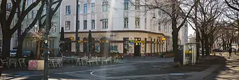Kriemhildplatz with a view of the tree-lined Markgraf-Rüdiger-Straße and Café Kriemhild.