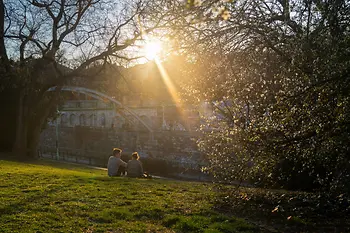 A couple sits in the city park enjoying the spring atmosphere