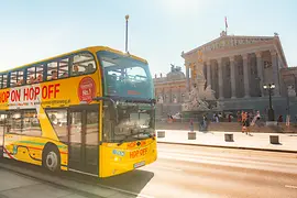 Bus à impériale jaune Hop-On Hop-Off de Vienna Sightseeing Tours devant le Parlement