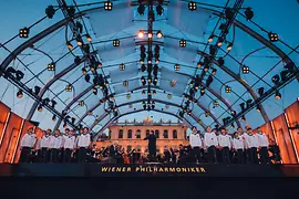 A Schönbrunn-kastély előtti szabadtéri színpadon: a Bécsi Filharmonikusok Tugan Sokhiev vezényletével és a Bécsi Fiúkórus.