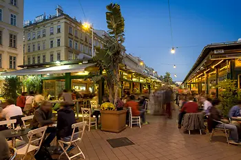 Débordement d'animation dans les établissements du Naschmarkt, vue extérieure avec personnes 