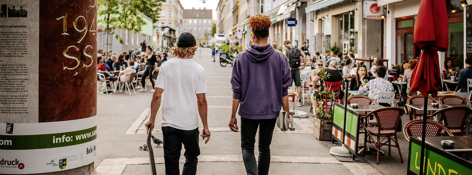 Menschen sitzen in Gastgärten