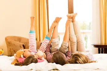 Children lying on a hotel bed