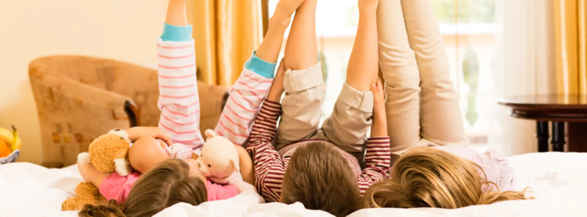 Children lying on a hotel bed