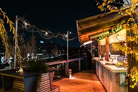 Personnes buvant du punch sur une terrasse avec vue sur le Canal du Danube
