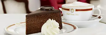 Una fetta di torta Sacher con panna montata