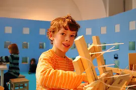 Bub mit Holzklötzen und Kabelbindern