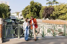 Un couple regarde un téléphone portable sur un pont au Stadtpark