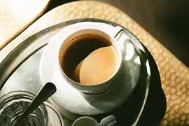 Un plateau en argent avec une tasse de café et un verre d'eau