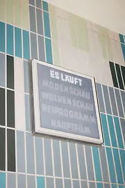 Gartenbaukino Innenansicht, Leuchtschild mit Aufschrift "ES LÄUFT"