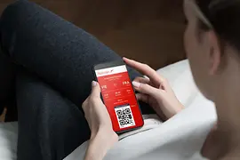 Persona con smartphone en la mano que usa la aplicación Austrian App.