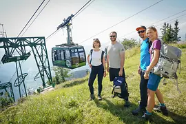 Hikers on the Rax plateau, behind them the Rax cable car