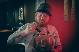 Head chef Lukas Mraz takes a pickle out of a jar of pickles