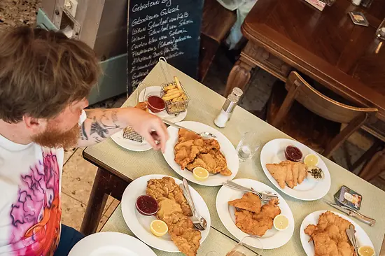 Deux personnes à table devant plusieurs Wiener Schnitzel