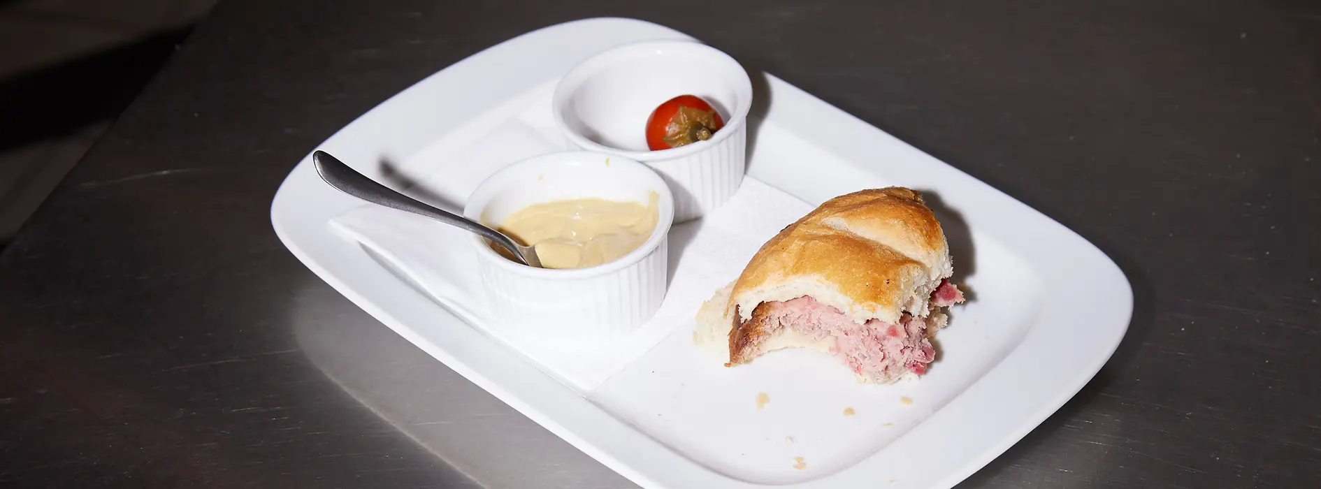 half-eaten "Leberkäse" meatloaf roll on a plate
