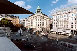 Vista exterior del centro de información turística de Albertinaplatz, coche de caballos y peatones en primer plano