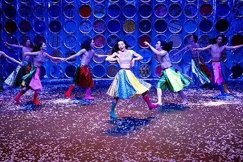 Korean dancers twirl around the stage in colorful skirts and boots.