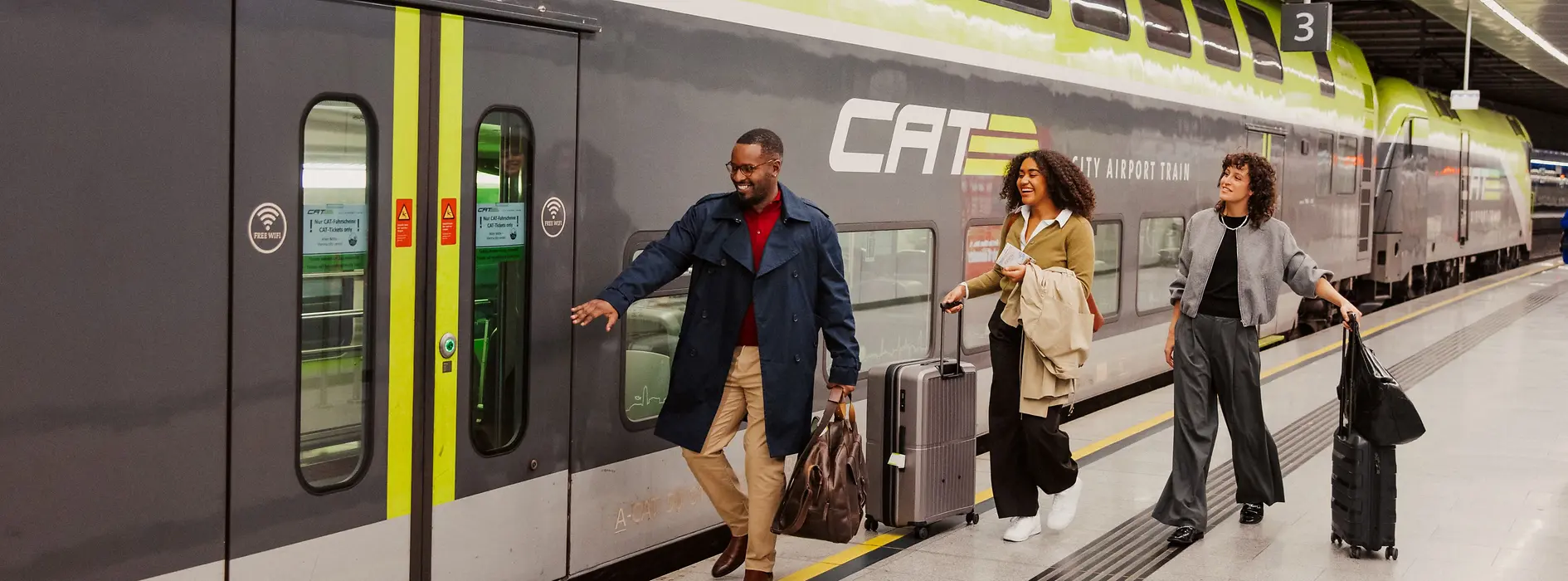 Două doamne și un domn urcă la bordul trenului expres al aeroportului City Airport Train. 