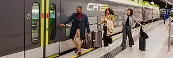 空港急行列車シティ・エアポート・トレインに乗り込む2人の婦人と1人の紳士。