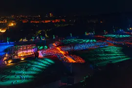 A Bécsi Filharmonikusok 2024-es Nyáréji koncertje a schönbrunni kastélynál, kivilágított közönséggel és kerttel éjjel
