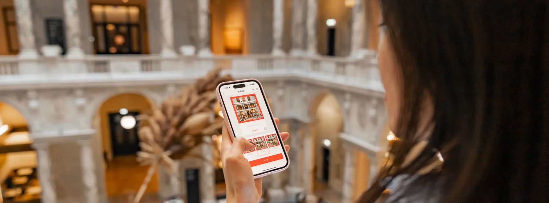Dame mit dunklen Haaren mit einem Smartphone in der Hand.