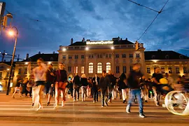 Museumsquartier bei Nacht und passierenden Menschen
